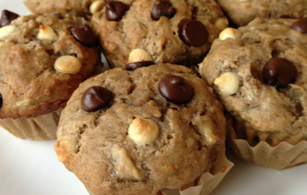 banana chocolate chip muffins on a plate with bananas in the background