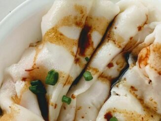 shrimp rice roll drizzled with a sweet soy sauce in a white plate