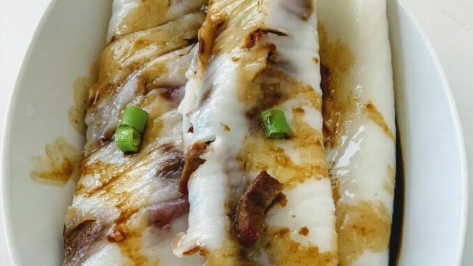 Make-Tasty-Char-Siu-Rice-Rolls-With-a-Pizza-Pan Char siu rice rolls plated in a white oval dish and drizzled with a sweet soy sauce