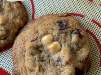 closeup of cranberry and white chocolate chip cookie on a silicone baking sheet