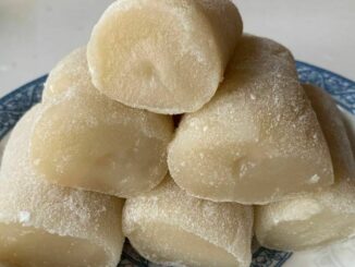 6 banana rolls stacked up like a pyramid on a blue and white dish